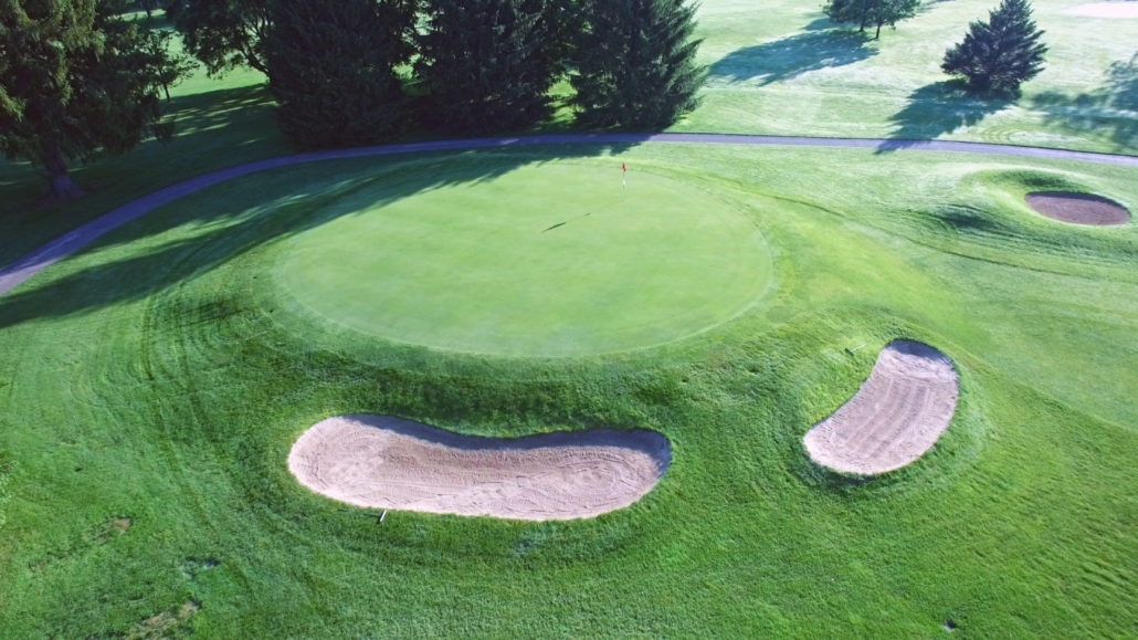 Aerial view of a golf hole with a red flag