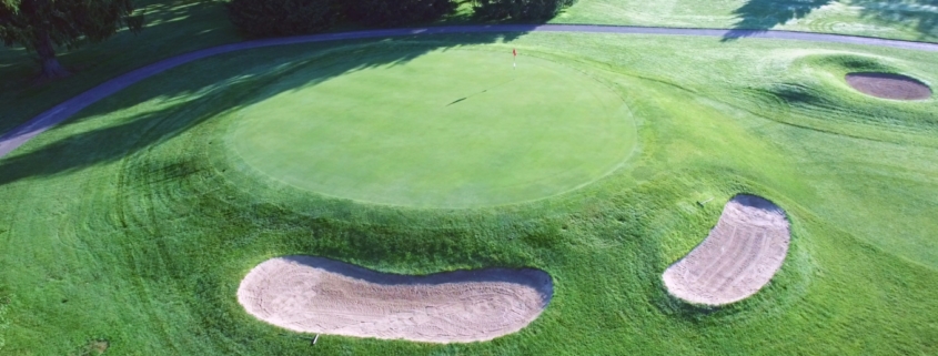 Aerial view of a golf hole with a red flag