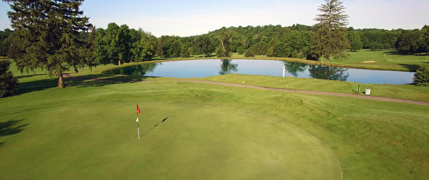 Golf course hole with a flag and a lake